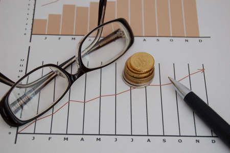 Stock chart,coins, pen and glassesの写真素材