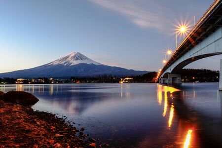 Landscape Fuji Mountain and Wooden Bridge with snow behind clear blue sky background and front a reflection in water lake.の写真素材