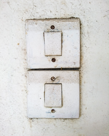 Dirty old switches on the white wallの写真素材