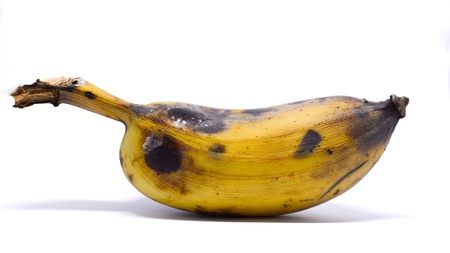 A ripe banana , isolated on white background.  It has yellow with the black marking. There are the empty space on the upper side which should be added a text or description.の写真素材