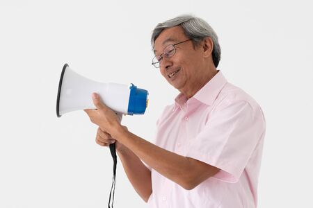 white studio portrait of senior asia retired elderly man shout loud announce by megaphone because need another hear his voiceの写真素材