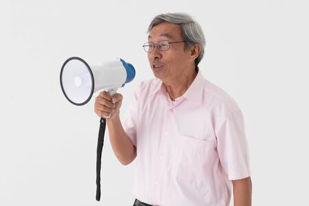 white studio portrait of senior asia retired elderly man shout loud announce by megaphone because need another hear his voiceの写真素材