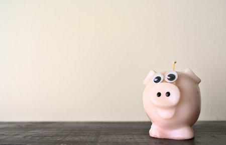 Pig shaped candle on a wooden ledgeの写真素材