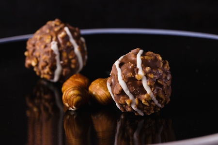 Nut and chocolate praline on elegant black plateの写真素材