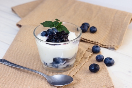 Glass cup of yogurt with blueberries and mint leavesの写真素材