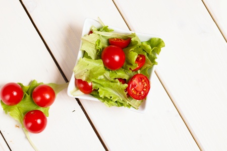 Top down view of bowl of cherry tomatoes and lettuce saladの写真素材