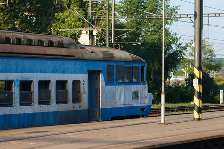 Old and very worn blue train stopped at some platform in central Europe