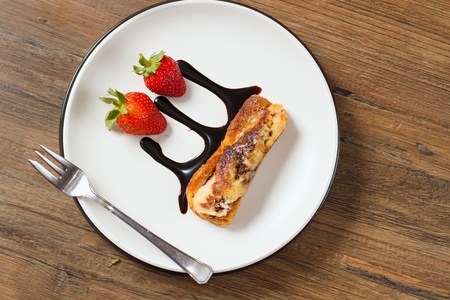 3Top down view on rolled french toast on a plate with strawberries and chocolate topping - decoratively served dessertの写真素材