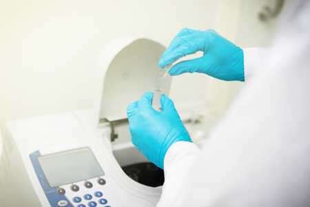 Scientists are measuring the absorption of light with a Spectrophotometry machine.の写真素材