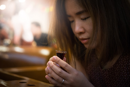 A believer is praying and she is involved in a Holy Communion.の写真素材