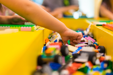 Little boy playing with lots of colorful plastic toys, building different animals and objectsの写真素材