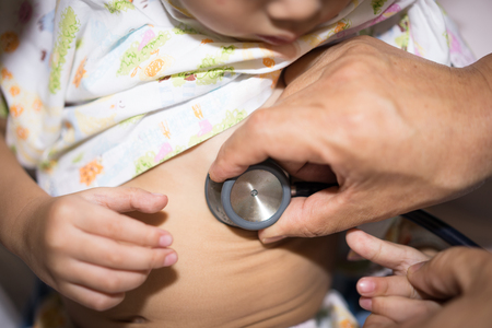 A  grandpa check up his sick grandson in the hospital.の写真素材