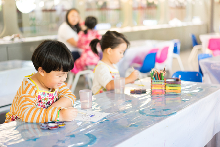 A boy is painting in the study room.の写真素材