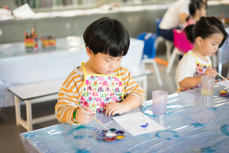 A boy is painting in the study room.の写真素材
