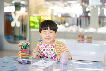 A boy is painting in the study room.の写真素材