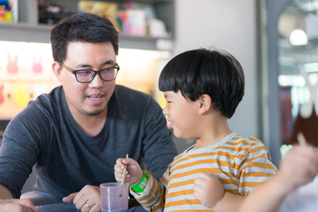 Father and son are painting together in the study room.の写真素材