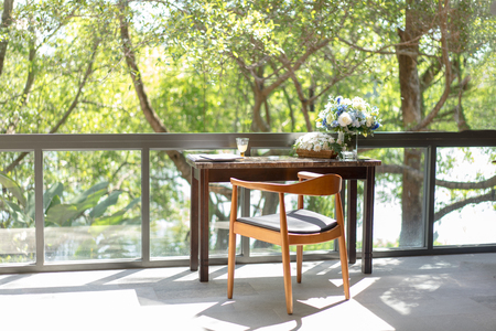 The relax corner and workspace, There are books, newspaper and juice on the wood table at the front of the window.の写真素材