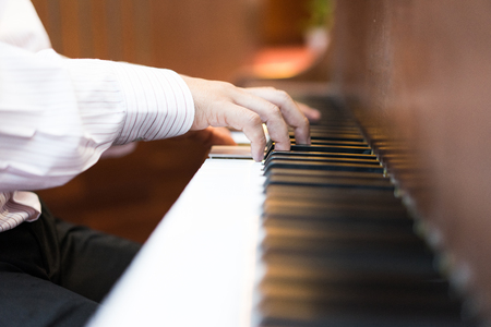 A pianist hand on piano keyborad. A pianist is playing a song at the church.の写真素材