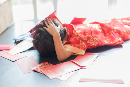 happy chinese new year. A cute asian little boy have many red envelopes. There are Chinese blessing words Longevity, auspicious and wealthy in the Chinese suit.の写真素材