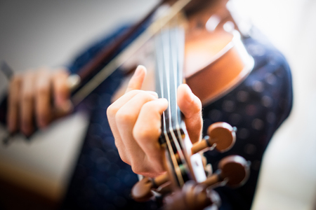 A young man is playing a violin in the sunday service at the church.の写真素材