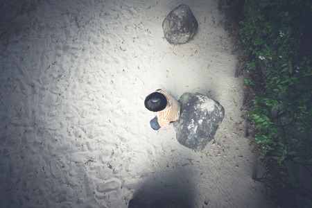 A boy is playing sand alone at the playground in the eveningの写真素材