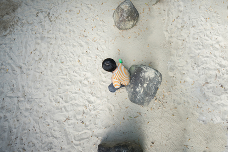 A boy is playing sand alone at the playground in the eveningの写真素材