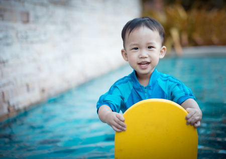 A happy asian boy is playing at the pool.の写真素材