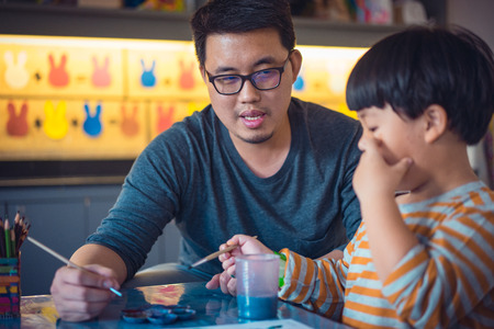 Father and son are painting together in the study room.の写真素材