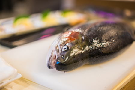 fresh salmon on white chopping board, for sashimi at the japanese restaurant.の写真素材
