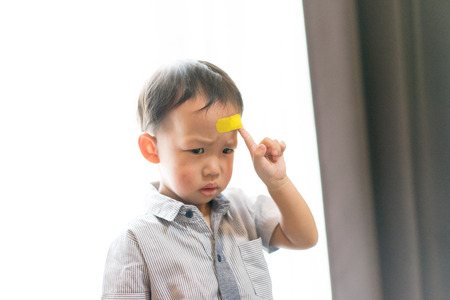 Children have ulcers at the head. His parents took the wound plaster.の写真素材