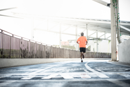 One man was running on a blue treadmill in the city.の写真素材