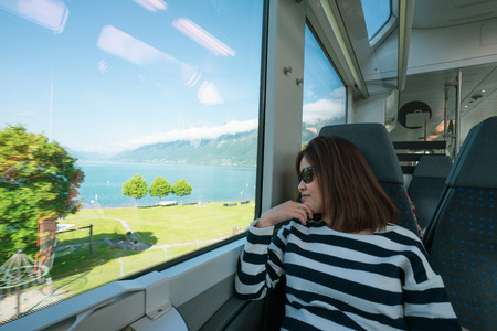 A working woman travels and enjoy the beautiful view in train at Europe.の写真素材