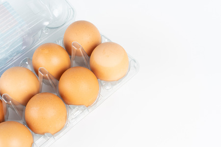 the pack of eggs in plastic packaging with white background.