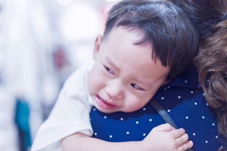 A asian baby boy is hugging his mother and  crying.の写真素材