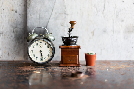 Old alarm clock and coffee grinder and cactus on the iron table rust in the concept of time and wake up to life.の写真素材