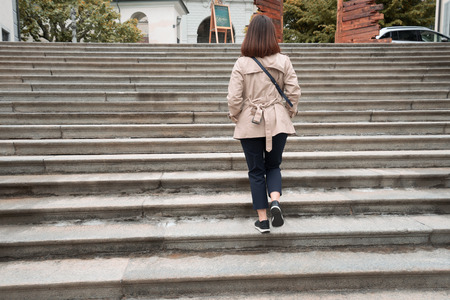 Working woman is walking up the vintage stairs at Eurpoe park.