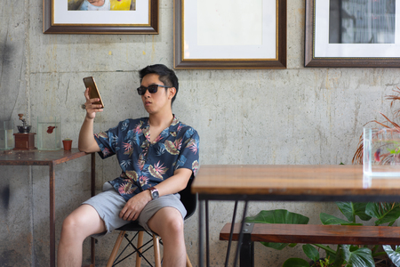 A hipster boy with sunglasses in a loft cafe.