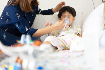 A mother is helping the sick son in the hospital.の写真素材