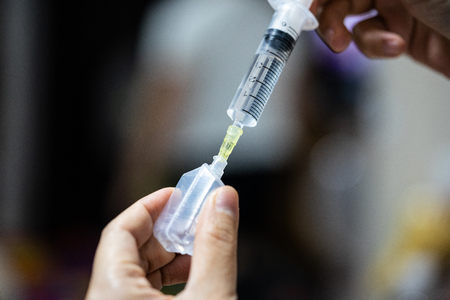 A syringe in the hands of a nurse. She is preparing to vaccinate children.