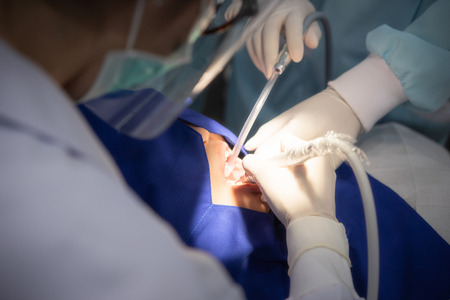 The dentist has tooth extraction and dental treatment at the clinic because of this great toothache of the woman.の写真素材