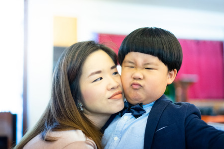 A naughty boy and his mother are playing In the church with formal suit.の写真素材