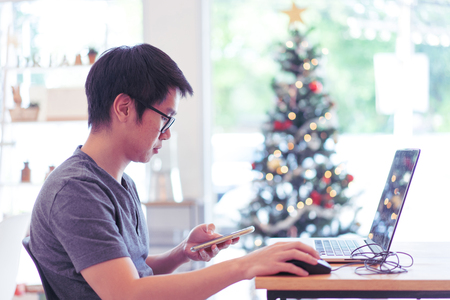 A freelance graphic designer is working hard in holiday with his computer.の写真素材