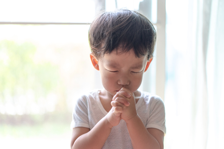 A little prayer, A boy is praying seriously and hopefully to Jesus in the morning.の写真素材