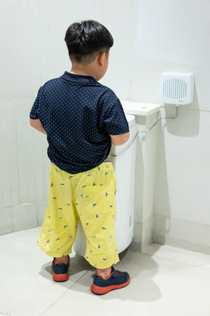 A boy is pissing himself in the bathroom.の写真素材