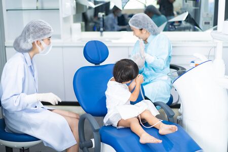 An Asian boy having teeth examined at dentists: Healthy lifestyle, healthcare, and medicine concept.の写真素材