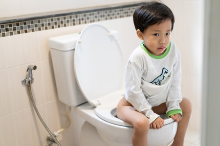 A boy is sitting on toilet with suffering from constipation or hemorrhoid.の写真素材