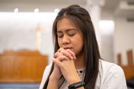 Asian women praying in a worship room in a Christian church.の写真素材