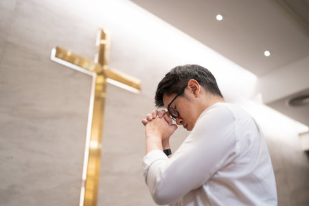 Asian man praying in a worship room in a Christian church.の写真素材