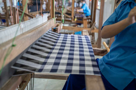 Weaving of cotton from Thailand, cotton weaving in the traditional manner, weaving by ourselves. Selective focus.の写真素材