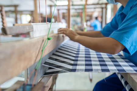 Weaving of cotton from Thailand, cotton weaving in the traditional manner, weaving by ourselves. Selective focus.の写真素材